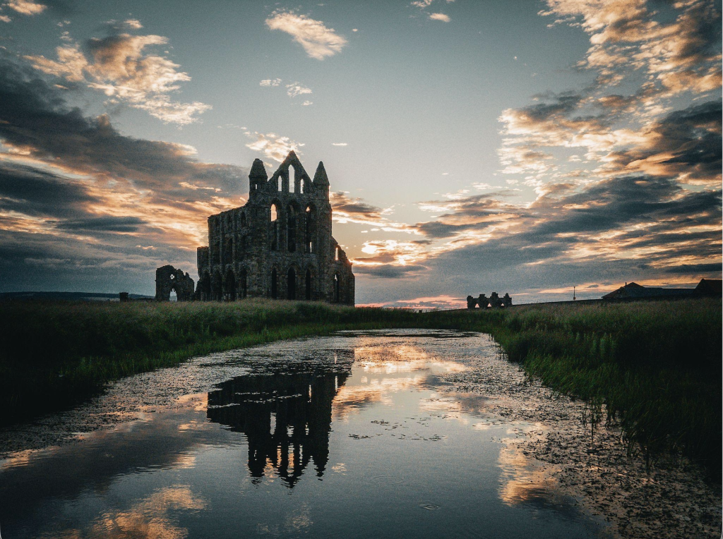 Whitby Abbey ruins with sunset and reflections